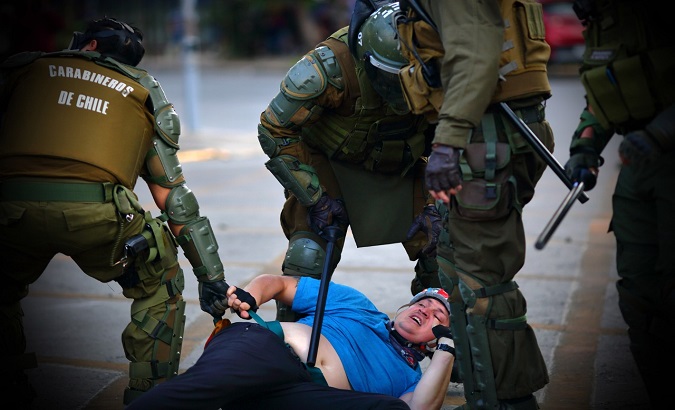 Police officers arrest a demonstrator, Chile, 2019.