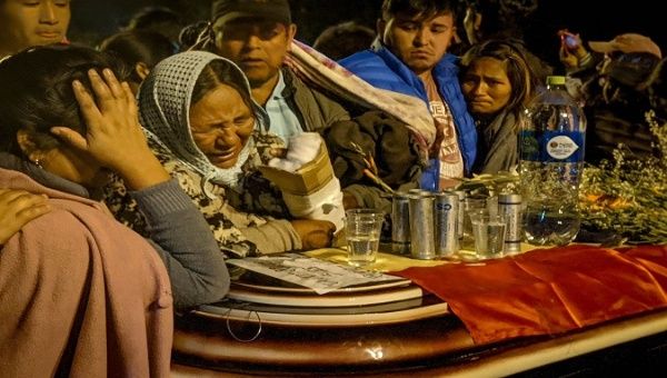 Family of a massacre victim mourns over the coffin, Sacaba, Bolivia, Nov. 2019.