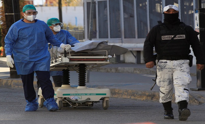 A nurse transfers the corpse of a man who succumbed to the new coronavirus, Juarez, Mexico, Jan. 6, 2021.