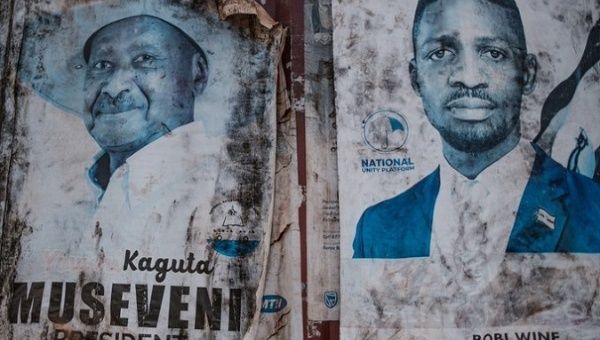 Posters of presidential candidates on a wall, Uganda, 2021.