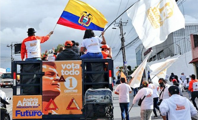 Banner with the image of Rafael Correa is displayed on Arauz-Rabascall binomial caravan, Jan. 7, 2021.