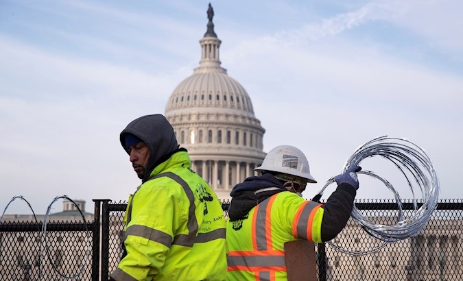 Workers install razor wire atop fencing outside the Capitol, Washington, DC, U.S., Jan. 15, 2021.
