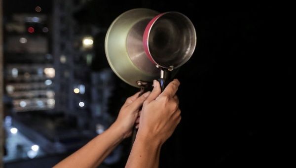 A person rings his pot in protest against the management of the COVID-19 pandemic, Rio de Janeiro, Brazil, Jan. 16, 2021.