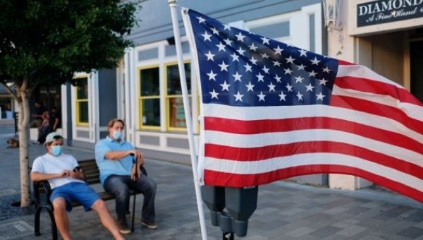 People sit by the roadside in Burlingame, California, the United States, July 4, 2020.