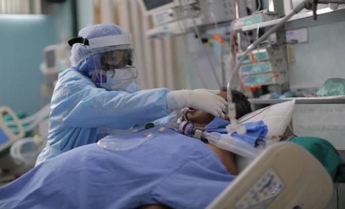 A healthcare worker treats a COVID-19 patient, El Callao, Peru, Jan. 17, 2021.