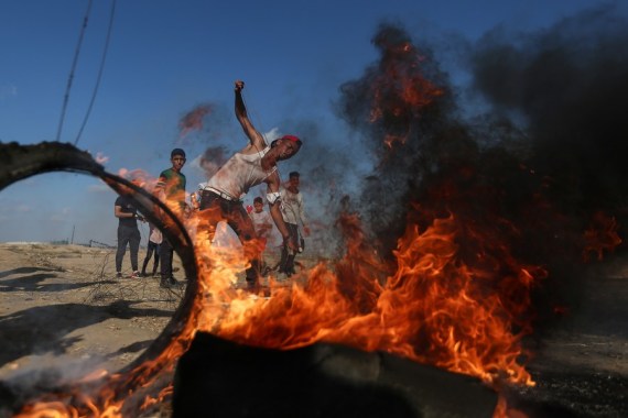 A Palestinian protester uses a slingshot to hurl stones at Israeli troops during clashes with Israeli troops on the Gaza-Israel border, east of southern Gaza Strip city of Khan Younis, Aug. 30, 2019