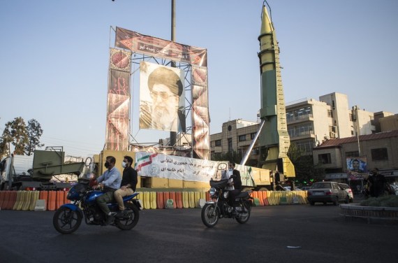 Iranians ride past a missile on display for the Defense Week in Tehran, Iran, on Sept. 27, 2020,  to mark the 40th anniversary of the Iraq-Iran war (1980-1988).