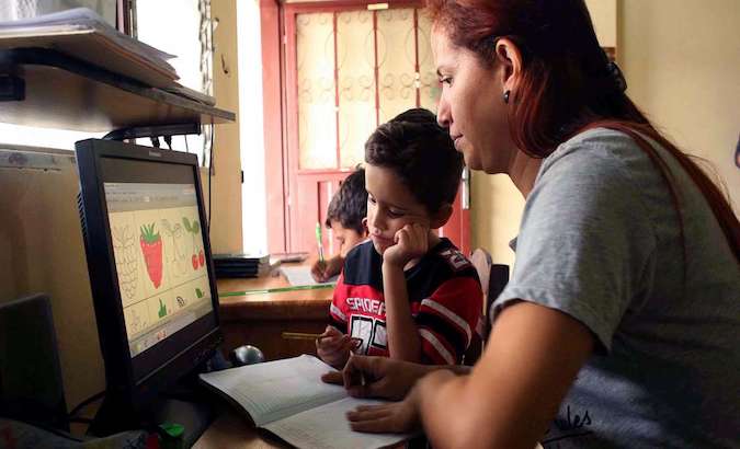 A mother accompanies her children during a remote class, Caracas, Venezuela, 2020.