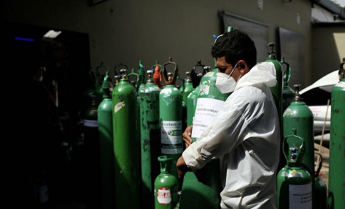A health worker unloads oxygen cylinders from a truck at a hospital in Manaus, Brazil.
