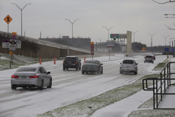 Vehicles move on a snow-capped road in Houston, Texas, the United States, on Feb. 15, 2021.