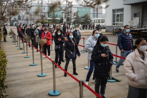 People wait in line at a COVID-19 vaccination site in Daxing District of Beijing, capital of China, Feb. 21, 2021.