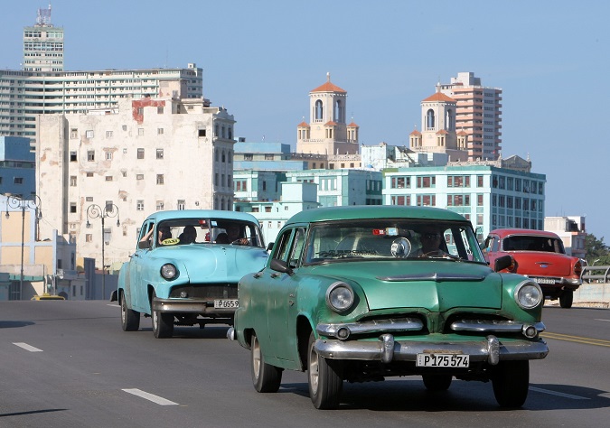 Vintage American cars are rolling along the Gulf Avenue, locally known as El Malecòn, in Havana, Cuba.