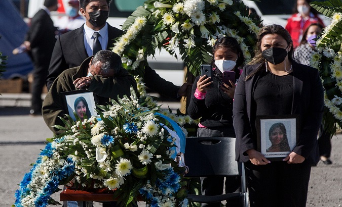 Family members of a migrant weep as they receive her coffin, Guatemala, March 12, 2021.