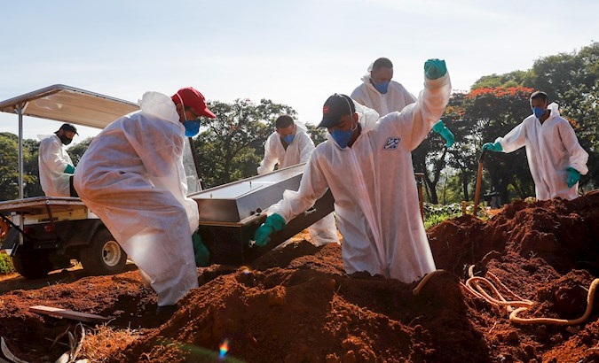 Workers rush to bury corpses in the Vila Formosa cemetery, Sao Paulo, Brazil, March 24, 2021.