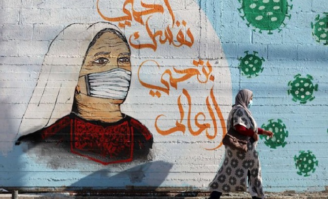 A woman walks past graffiti reading, 