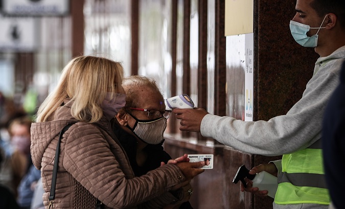Health personnel checks an elderly woman who will be vaccinated, Buenos Aires, Argentina, March 18, 2021.