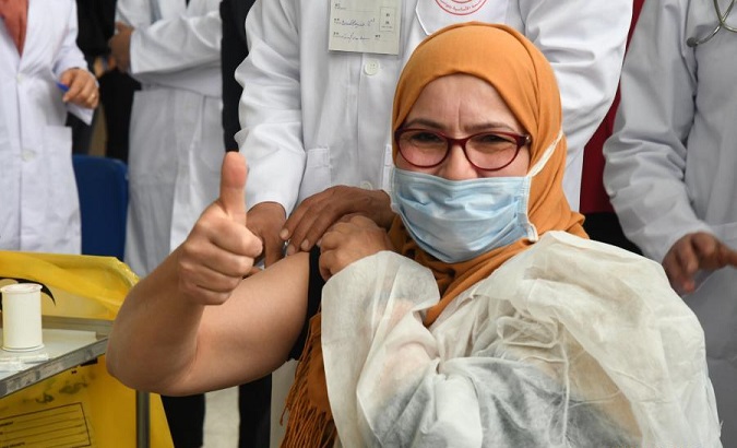A woman receives a COVID-19 vaccine in Tunis, Tunisia, March 13, 2021