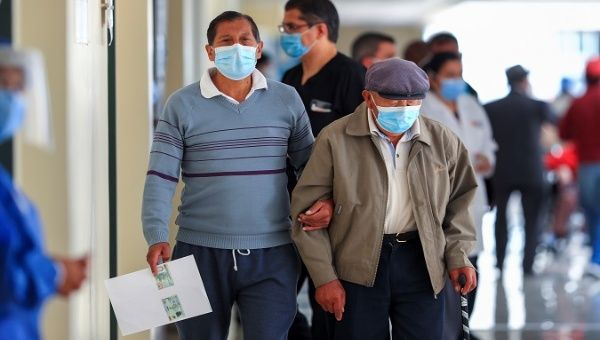 An older adult accompanied by a family member goes to the hospital to get vaccinated, Quito, Ecuador, March 25, 2021.