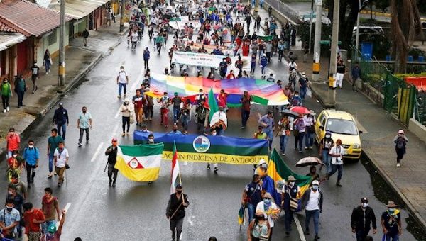 Members of the Indigenous Organization of Antioquia carry out cultural activities while walking the streets, today in Medellín
