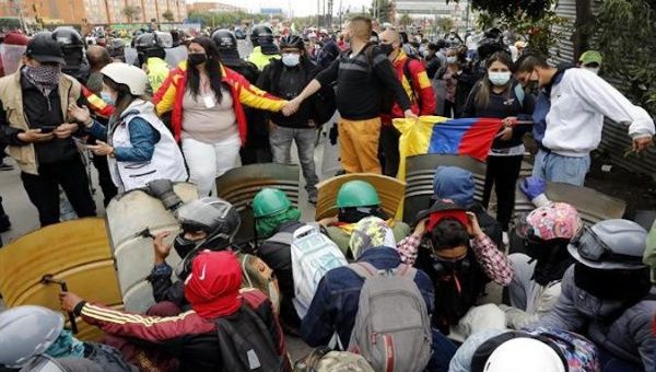 Protesters shield themselves from police officers in Bogota, Colombia, May 2021.