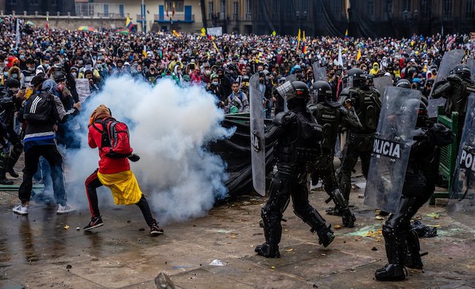 Police officers shoot at demonstrators in Bogota, Colombia, May 2021.
