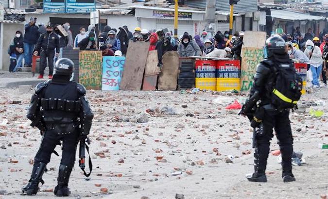 Demonstrators protect themselves from ESMAD agents, Bogota, Colombia, May 2021.