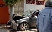 Citizen passes in front of the car where Marco Aurelio Ramirez lies dead, May 23, 2023.