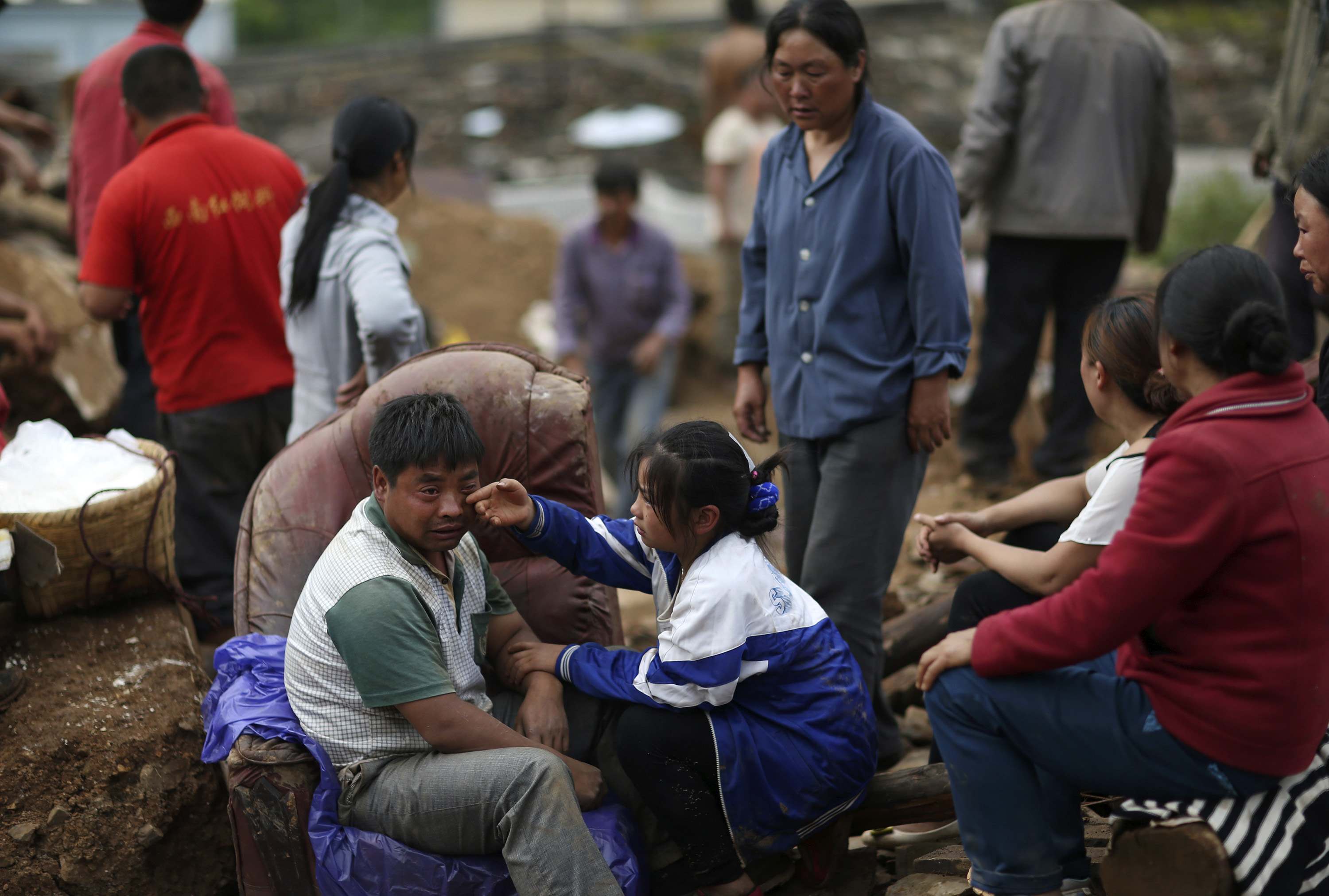 Liu Jiali (front L) cries as his daughter (C) wipes his tear after an earthquake killed Liu's wife and two other children in Longtoushan township of Ludian county, Yunnan province (Photo: Reuters)