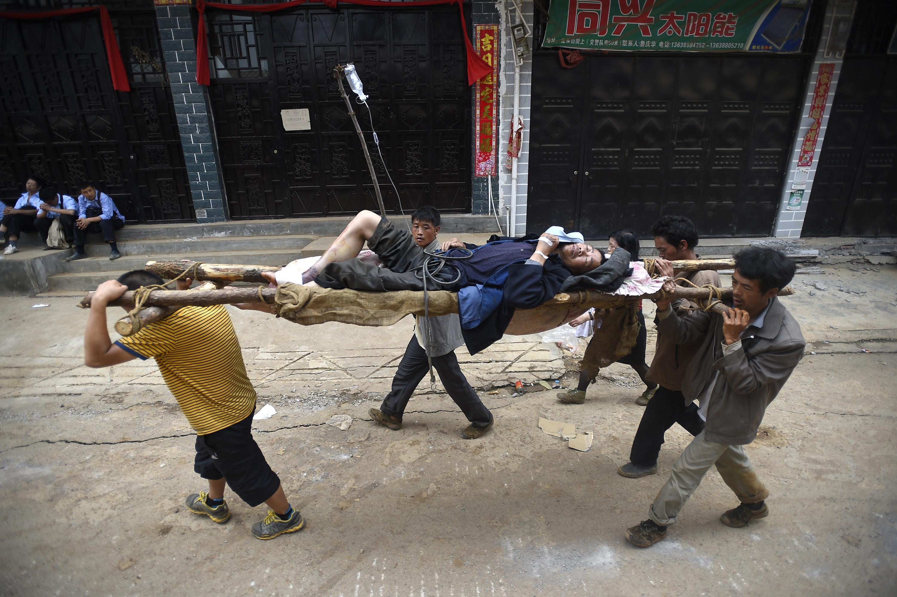 Rescuers carry an injured man with a makeshift stretcher after an earthquake hit Longtoushan township of Ludian county, Yunnan province August 4, 2014 (Photo: Reuters)