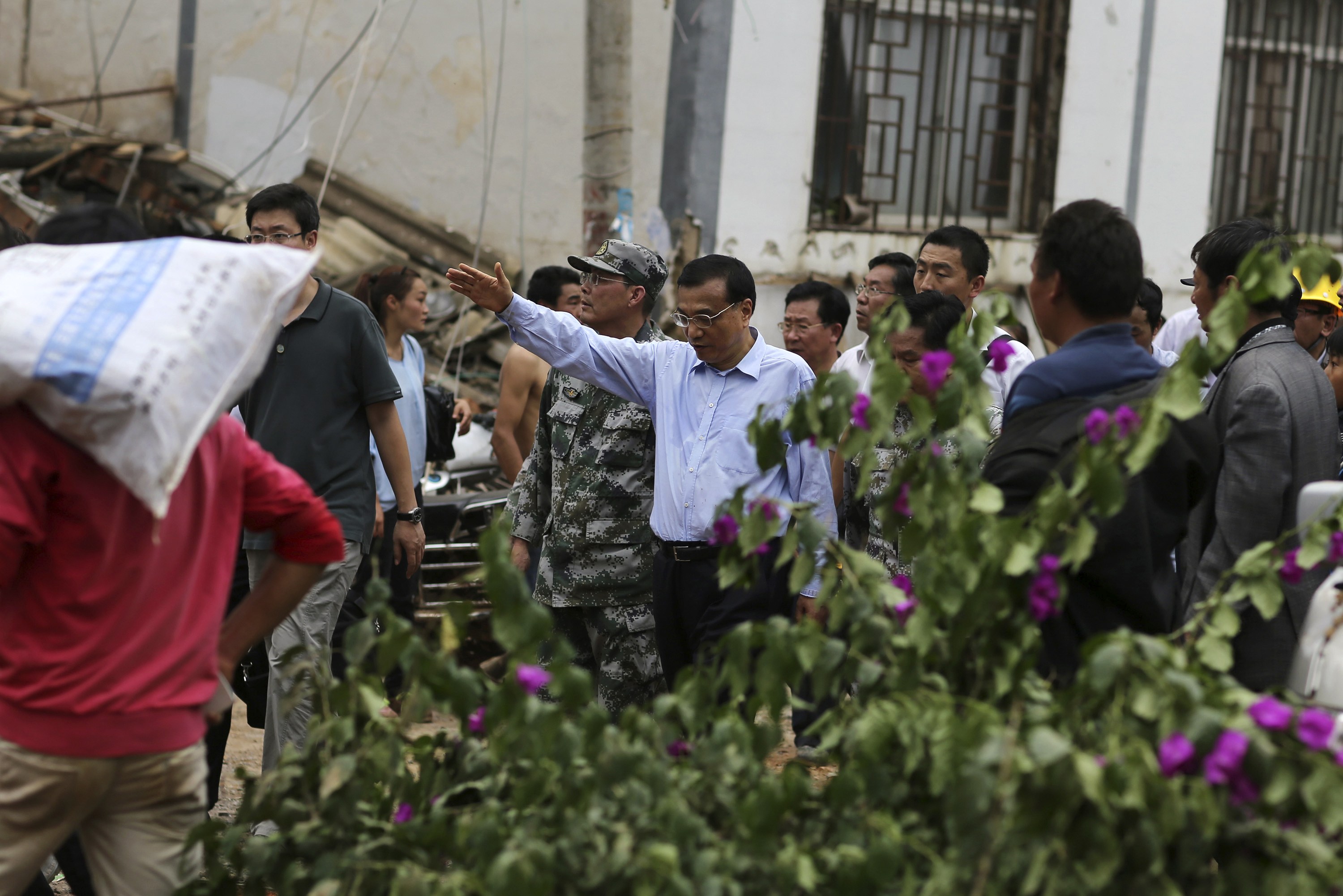 Chinese Premier Li Keqiang (C) talks to rescuers as he visits the earthquake-hit Longtoushan township of Ludian county, Yunnan province August 4, 2014 (Photo: Reuters) 