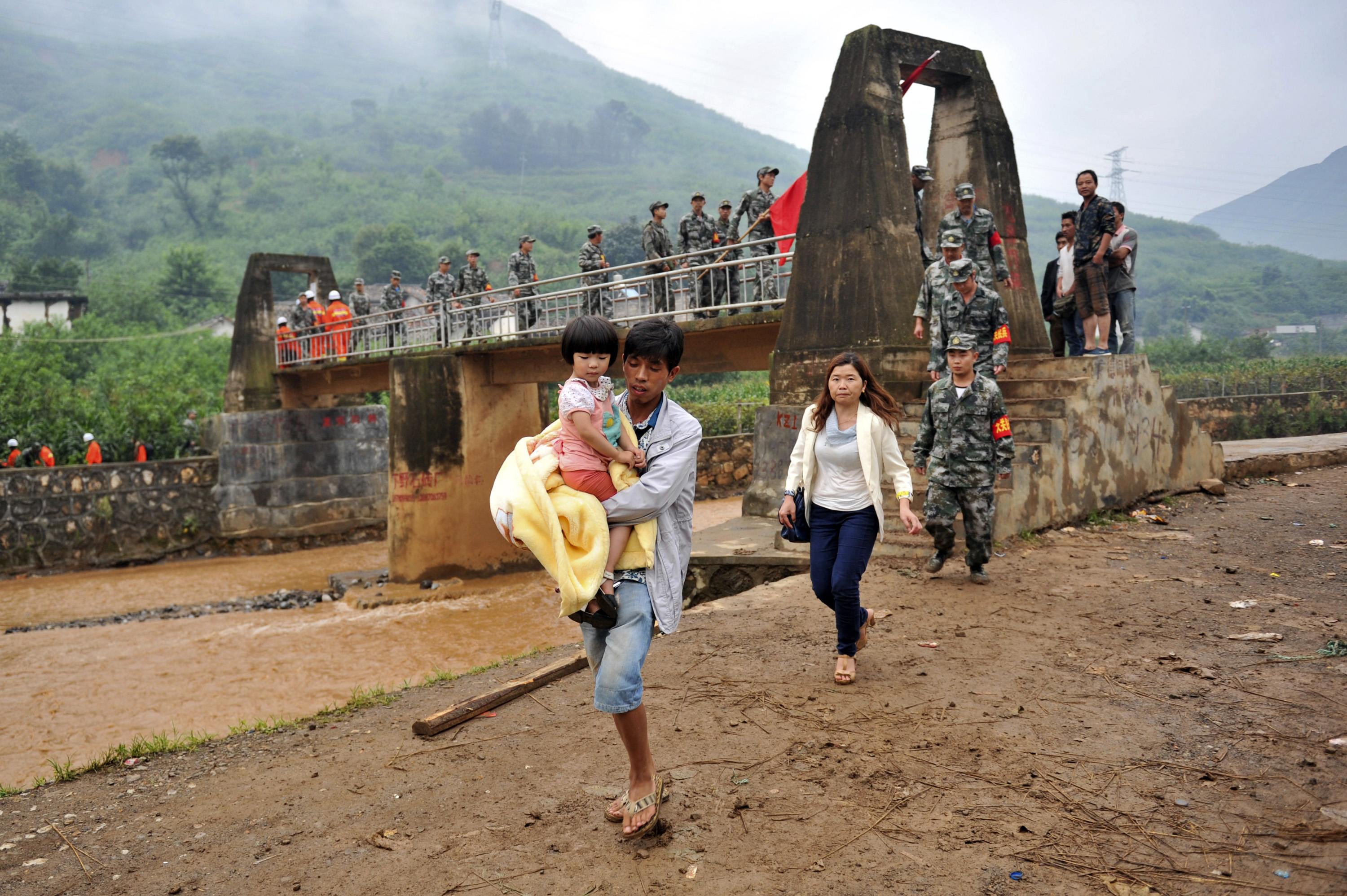 A man carries a girl as they are evacuated after a magnitude 6.3 earthquake hit Longtoushan town, Ludian county, Zhaotong, Yunnan province, August 4, 2014. (Photo: Reuters)