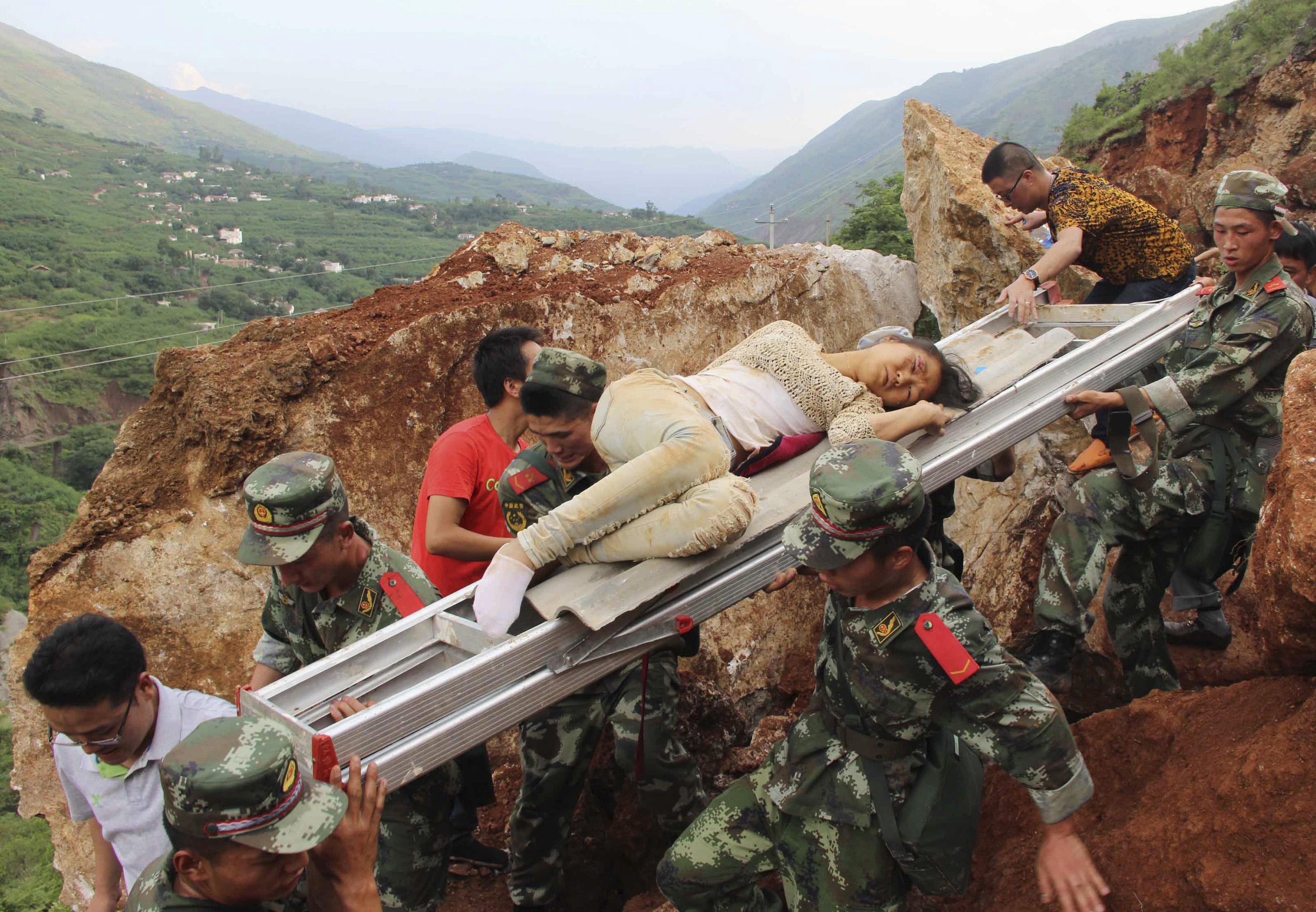 An injured woman is carried down a mountain on a ladder by rescue workers after a deadly earthquake hit Longtoushan town on Sunday, Ludian county, Zhaotong, Yunnan province, August 3, 2014. Picture taken August 3, 2014. (Photo: Reuters)