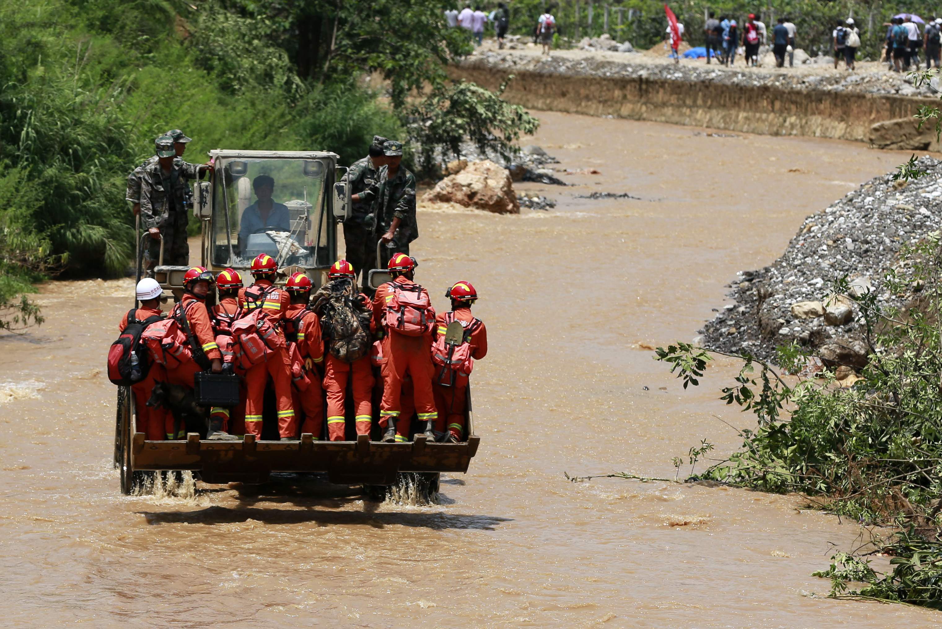 Rescue workers are transported into an earthquake zone on a front loader in Zhaotong, Yunnan province, August 5, 2014. (Photo: Reuters)