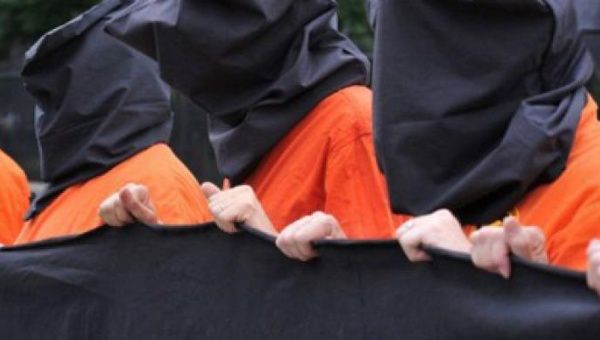 Anti torture protesters dressed in the orange jumpsuites and black hoods that are now emblamatic of the torture and abuse of terror suspects in the aftermath of 9/11 (Photo: AFP).