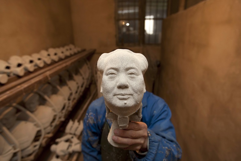 A worker makes a bronze statue of China's late Chairman Mao Zedong at a factory in Shaoshan, Hunan province, Dec. 7, 2014. 