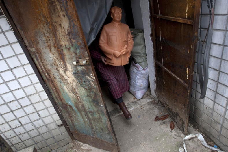 A worker carries a wax mould of China's late Chairman Mao Zedong as he walks out of a factory which produces statues of Mao in Shaoshan, Hunan province, Dec. 7, 2014.