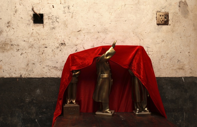 Newly made bronze statues of late Chinese Chairman Mao Zedong are seen covered by a red cloth at a statue factory in Mao's hometown of Shaoshan, Hunan province, Dec. 7, 2014.