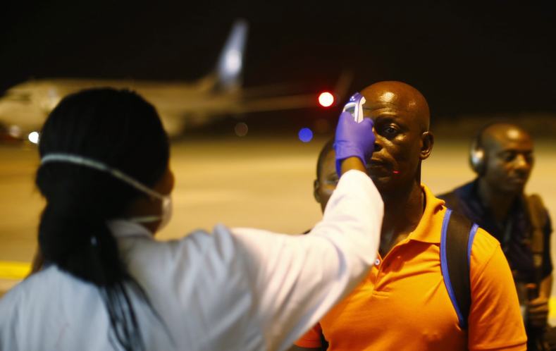 A health worker checks the temperature of a man arriving at Bata Airport. All teams arriving in Equatorial Guinea for the Cup must travel through the capital Malabo to be tested for the Ebola virus.