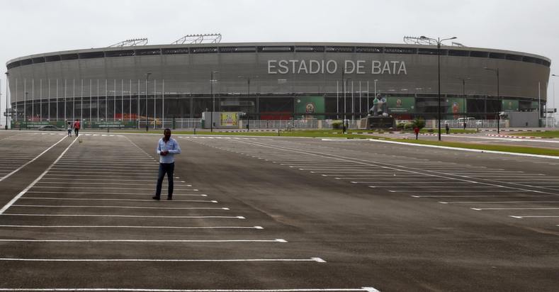 A man walks in front of the Estadio de Bata 