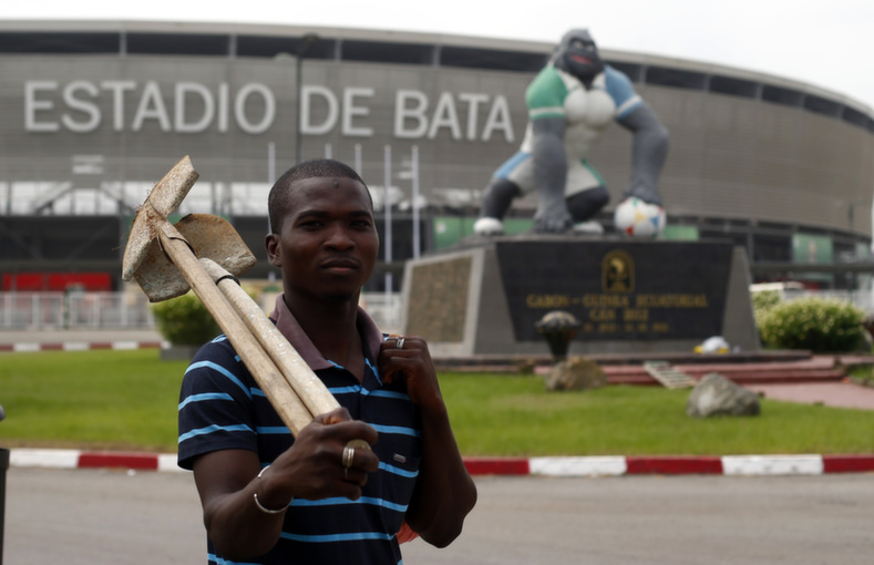 A construction worker walks in front of the Estadio de Bata 