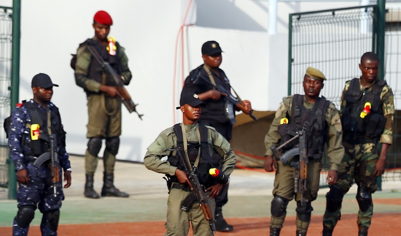 Soldiers and policemen take their positions as Equatorial Guinea's players check the field of the Estadio de Bata 