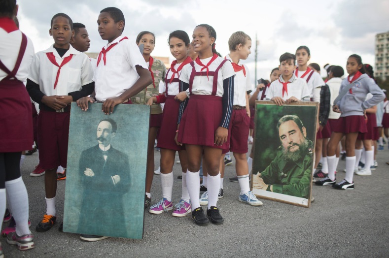Students hold portraits of Cuba's former President Fidel Castro (R) and Cuban independence hero Jose Marti near the memorial of Marti on Revolution Square in Havana on January 28, 2015
