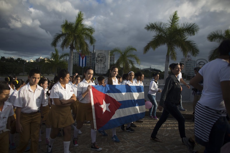 Students hold Cuba's national flag at the memorial of Jose Marti on Revolution Square in Havana on January 28, 2015