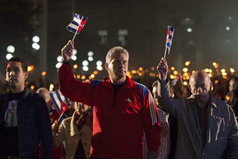 Cuba's First Vice-President Miguel Diaz Canel (C) and Vice President Jose Ramon Machado Ventura (R), hold Cuba's national flags during a march in celebration of the 162nd birth anniversary of Cuba's independence hero Jose Marti in Havana on January 27, 2015