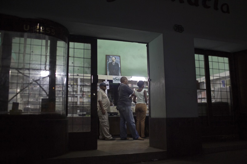 People line up in a pharmacy with an image depicting Cuban independence hero Jose Marti in downtown Havana on January 22, 2015