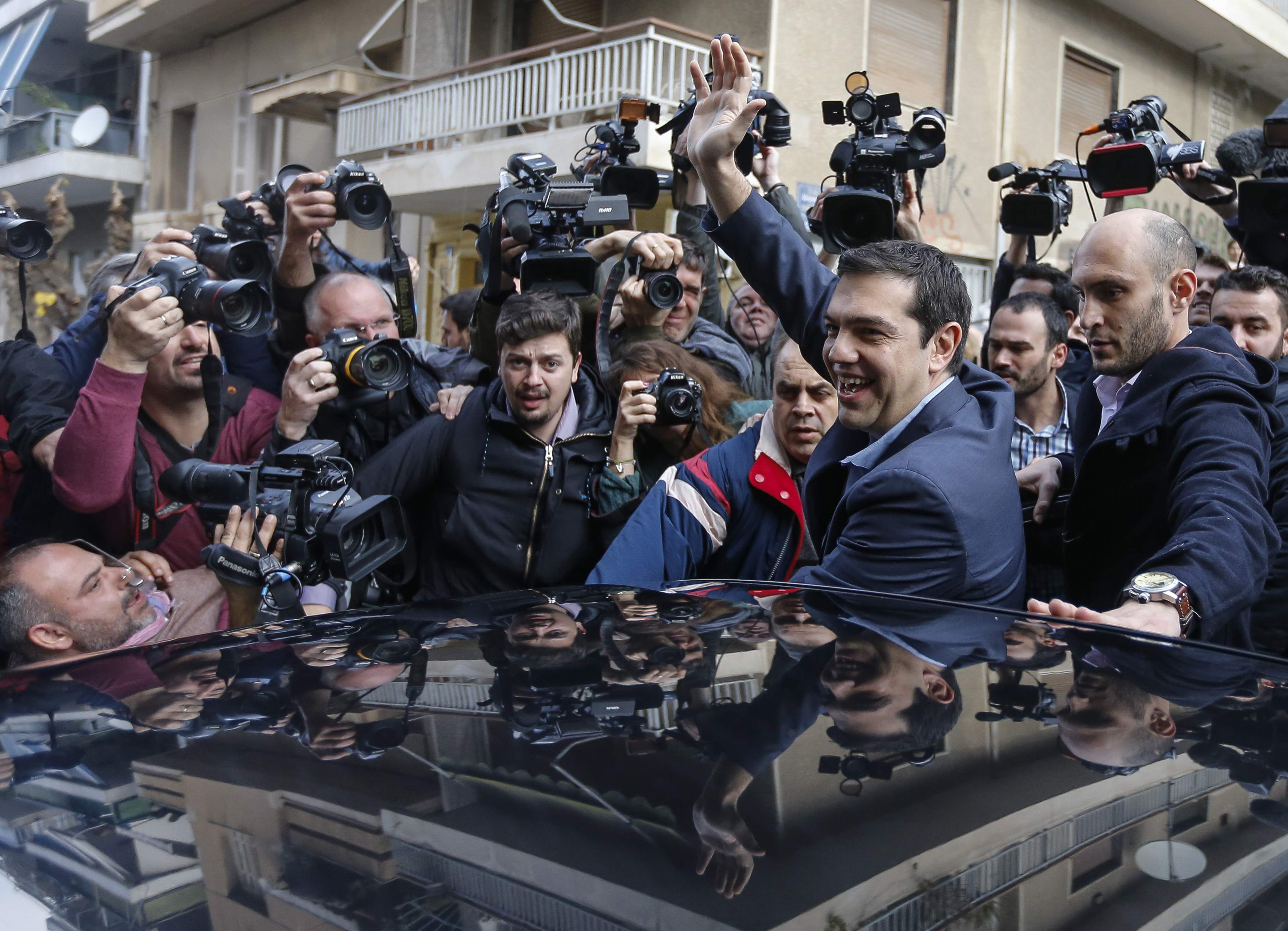 Greece's new Prime Minister Alexis Tsipras of Syriza waves as he leaves a polling station in Athens Jan. 25, 2015.