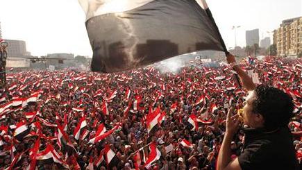 Protesters against Egyptian President Mohamed Mursi wave national flags in Tahrir Square in Cairo.