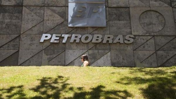 People walk past a Petrobras building in Rio de Janeiro, Brazil, on December 12, 2014.