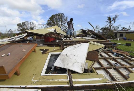 A local resident looks at his home destroyed by Cyclone Pam in Port Vila, the capital city of Vanuatu March 16, 2015.