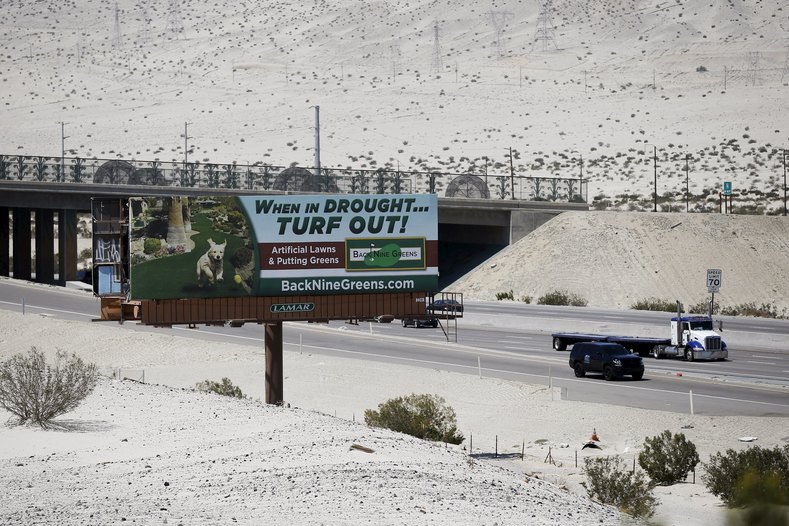 A sign advertising artificial turf is seen in Cathedral City, California, April 13, 2015.